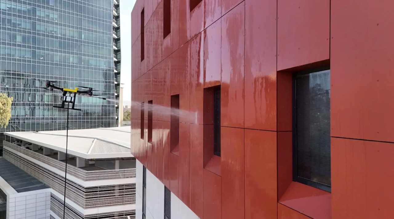 Apellix drone cleaning red commercial building facade