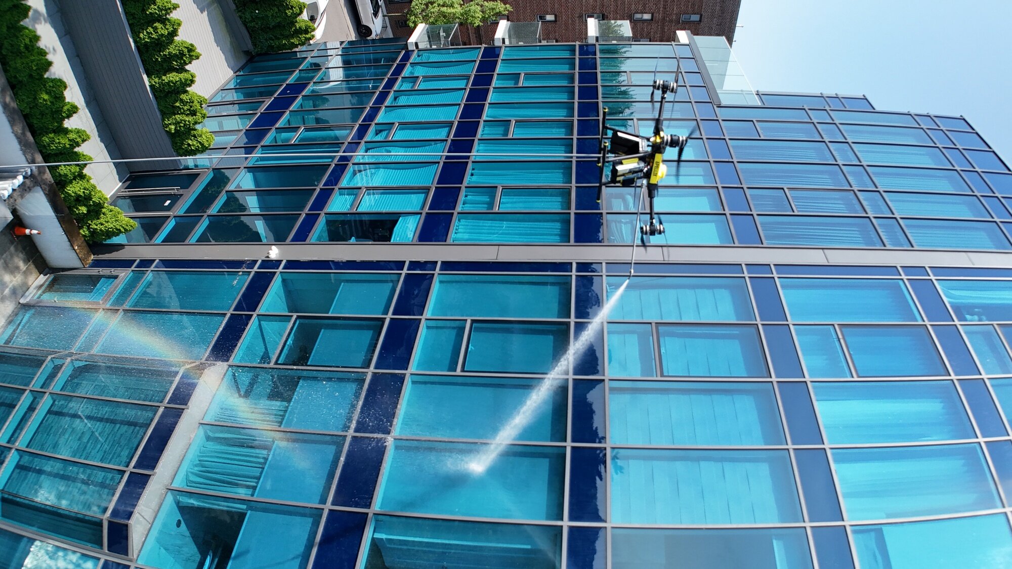 Apellix drone washing glass facade of high-rise building